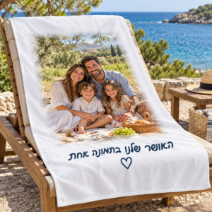 מגבת חוף עם תמונה משפחתית ממורכזת וכיתוב האושר שלנו בתמונה אחת על כיסא חוף