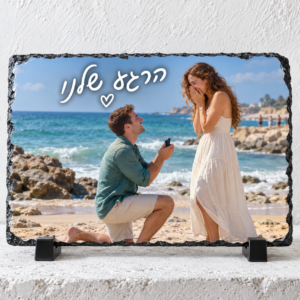 אבן בזלת מלבנית לרוחב עם הצעת נישואין בחוף וכיתוב לבן בכתב יד הרגע שלנו