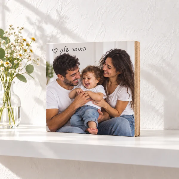 בלוק עץ סנדוויץ׳ בירץ׳ 15×15 ס״מ עם תמונה אישית, כיתוב עברי בכתב יד ולב חלול, דופן שכבות גלויה וקיר לבן מחוספס